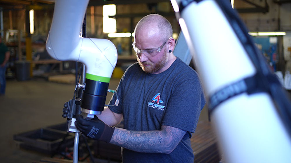 Welder programming a FANUC CRX Welding Cobot