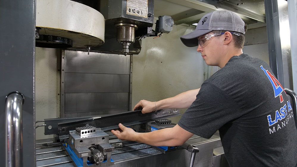 Manufacturing worker places metal into milling machine